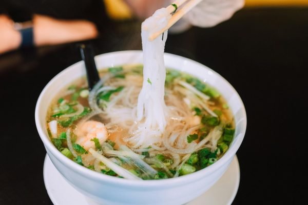 pexels-photo-6646067-6646067 A delicious close-up of a steaming bowl of Vietnamese pho with fresh herbs and noodles.